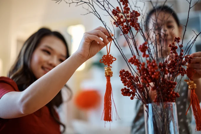 Women hanging up chinese new year decoration